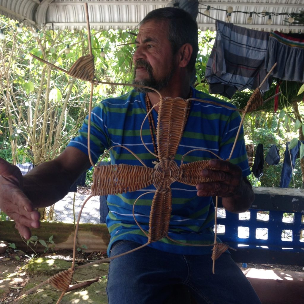 Edwin Marcucci holding a cross made with 'bejucos' (vines) from the Cupey Tree. Photo taken at his home in Adjuntas, PR
